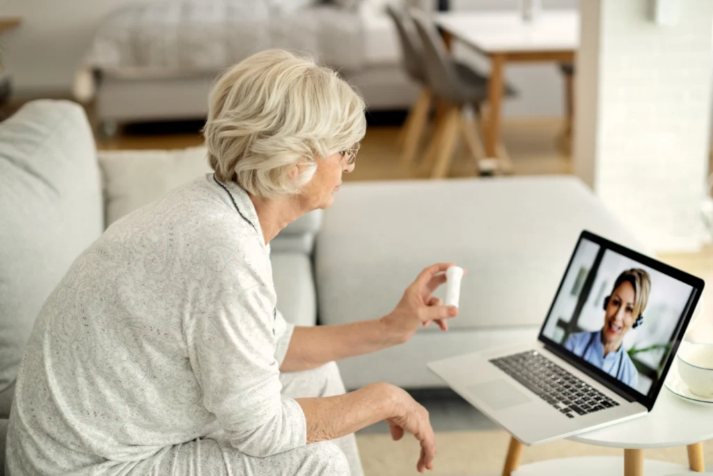 An old woman talking to a doctor on video call.