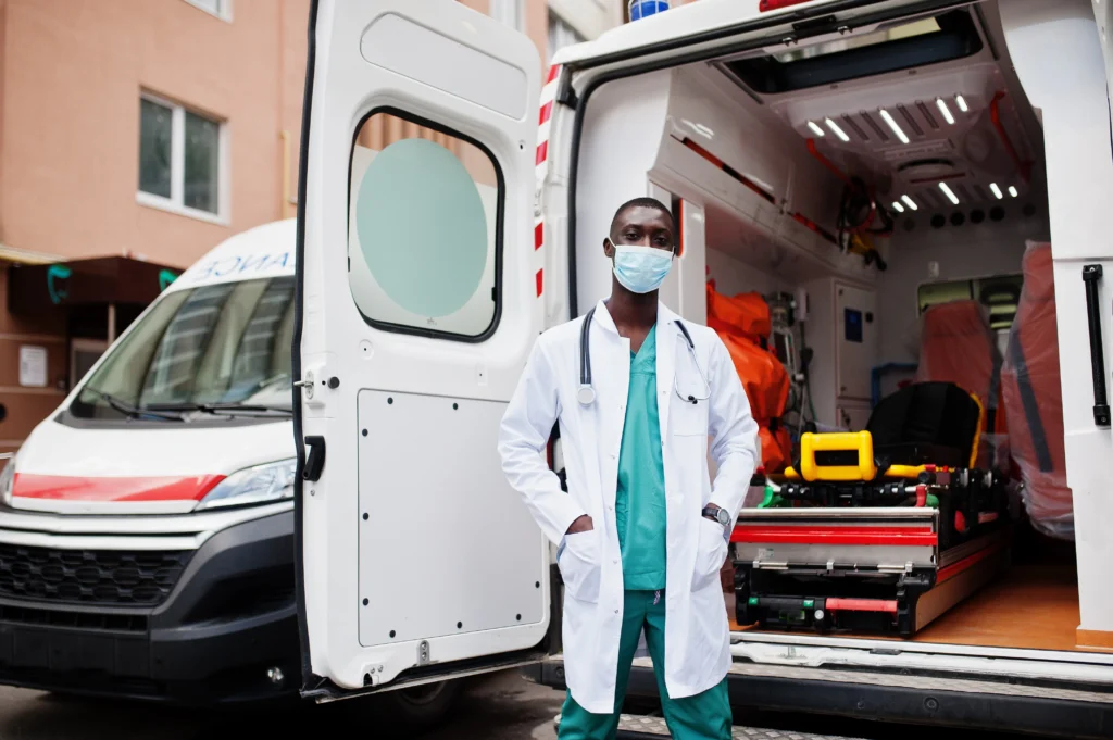 healthcare official Posing infront of a ambulance.